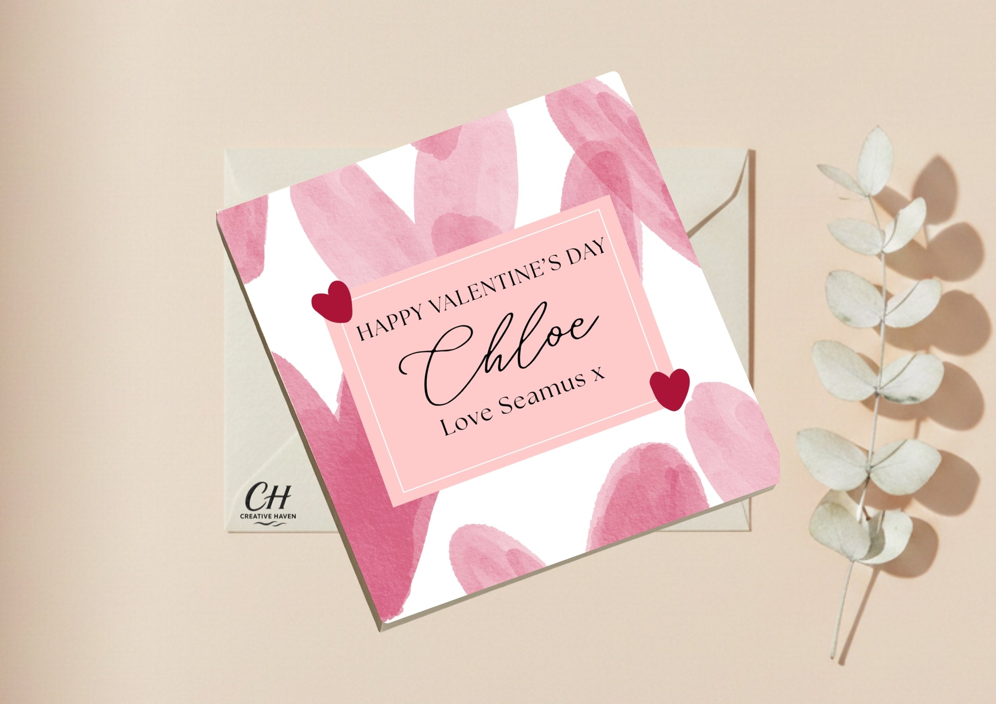 Valentine's Day card with pink and white abstract design, personalized message, and decorative elements on a beige background.
