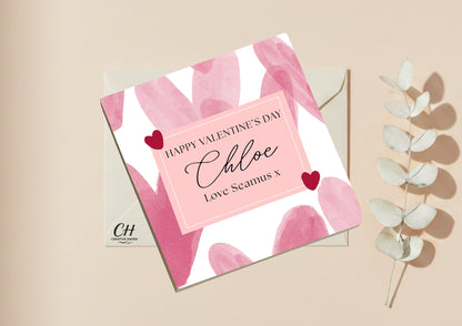 Valentine's Day card with pink and white abstract design, personalized message, and decorative elements on a beige background.