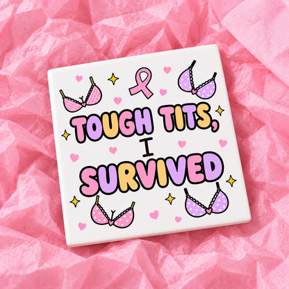 Square 10x10cm ceramic breast cancer awareness coaster with survivor design on pink tissue paper.