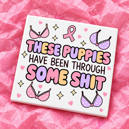 Square 10x10cm ceramic breast cancer awareness coaster with survivor design on pink tissue paper.