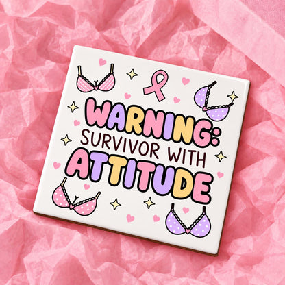 Square 10x10cm ceramic breast cancer awareness coaster with survivor design on pink tissue paper.